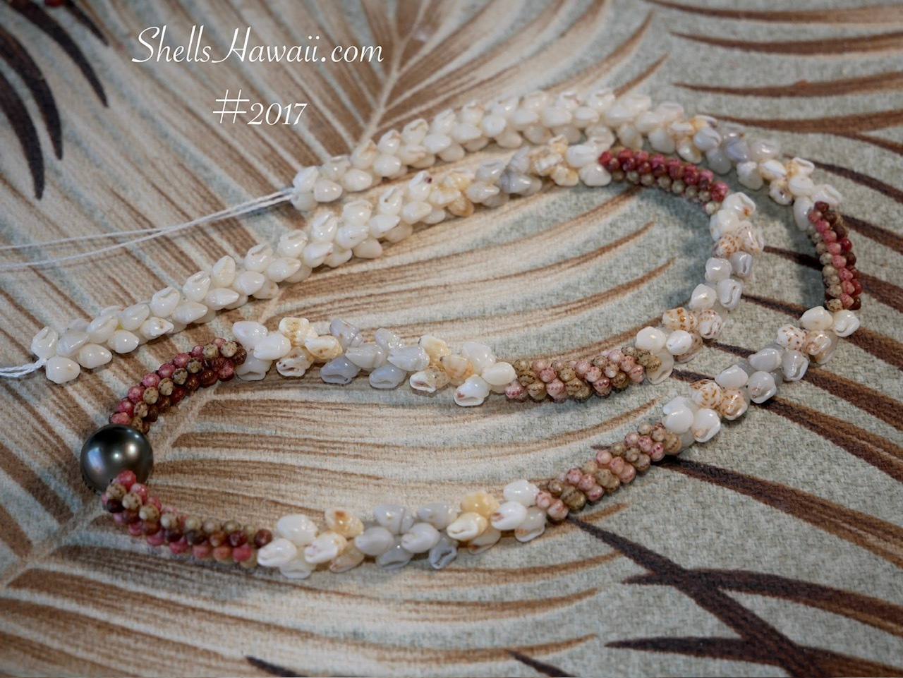 Completed traditional Niʻihau Kipona style shell lei ready for the clasp with Momi shells, Kahelelani shells, and a Tahitian pearl centerpiece.