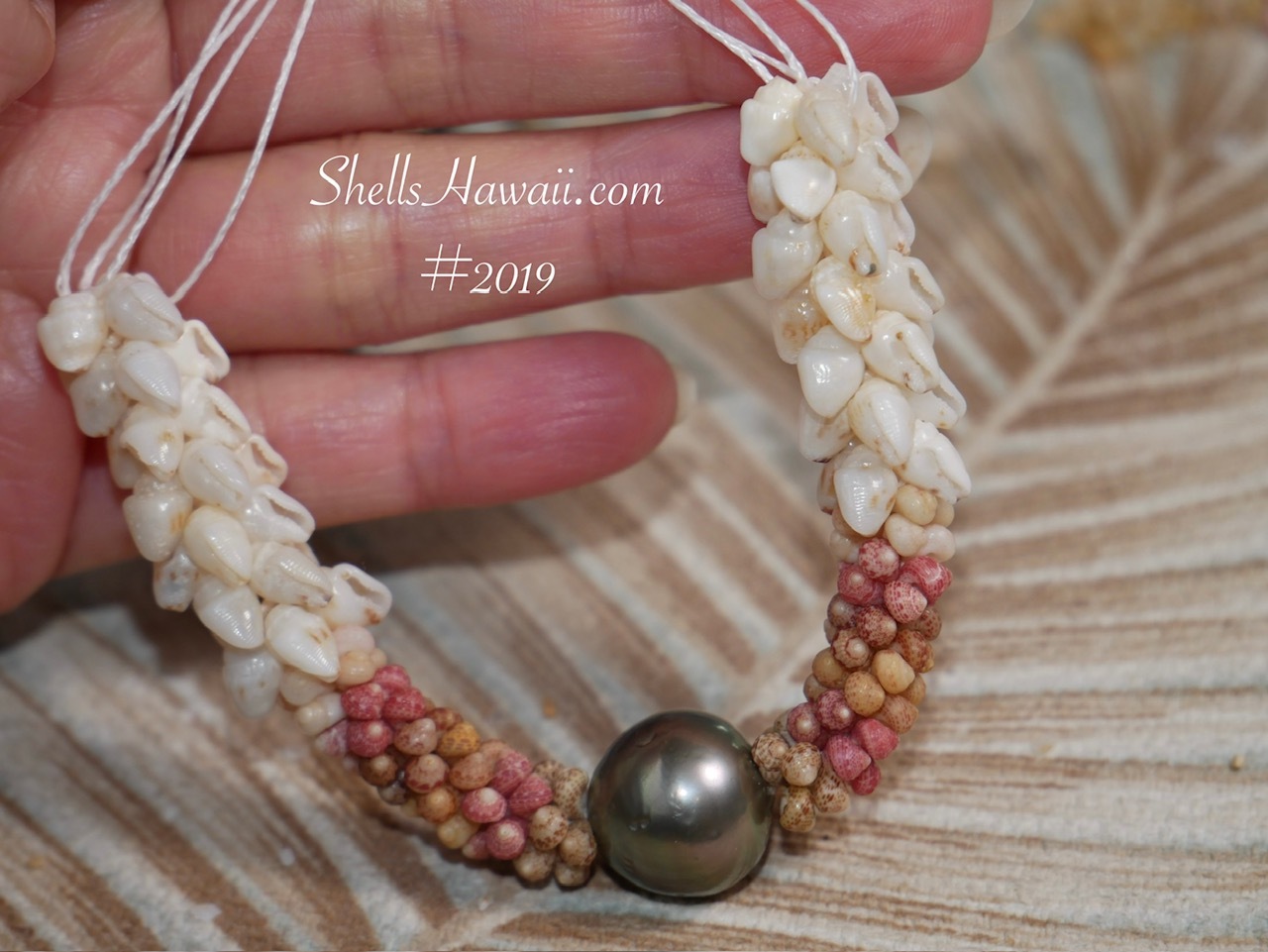 Center of Hawaiian Shell Lei Kipona Style #2019 featuring a Tahitian pearl surrounded by genuine Kahelelani shells from Kauaʻi (size 14.5) and Double Double Pikake sections made with Momi shells.