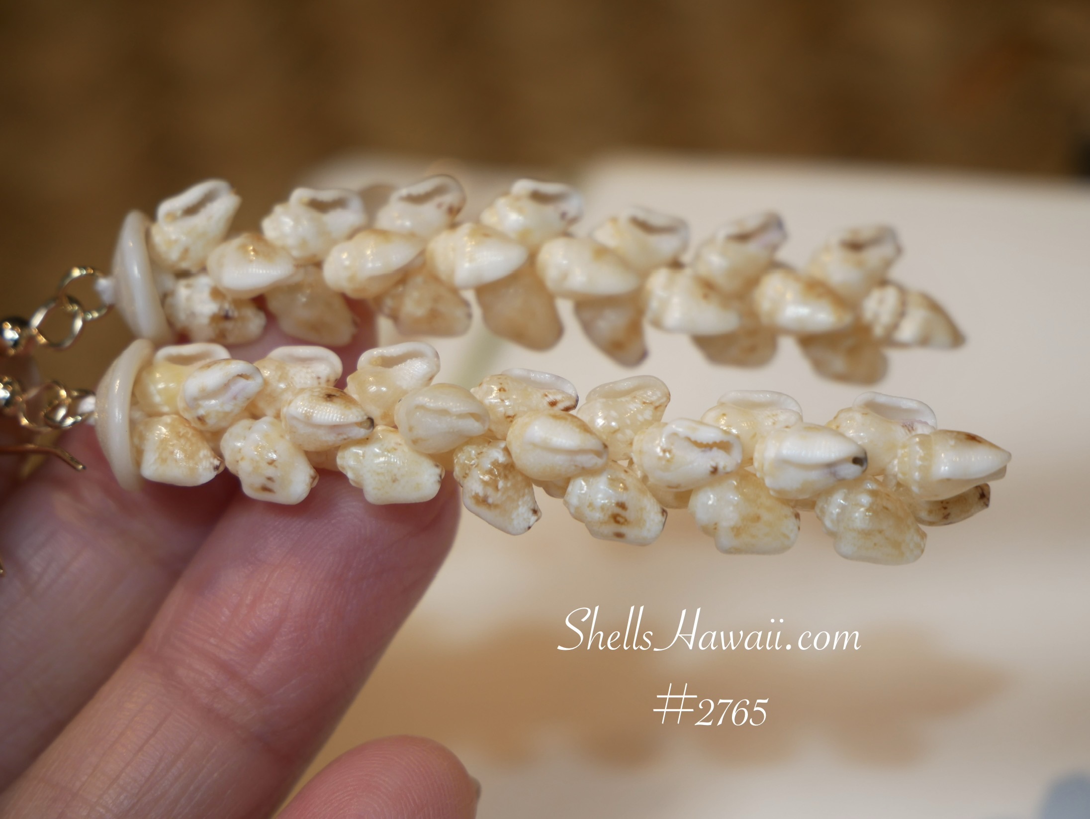 Close-up of handmade Niʻihau Momi shell earrings featuring light yellow Lenalena shells arranged in tighter Pikake style clusters with more even alignment and spacing.