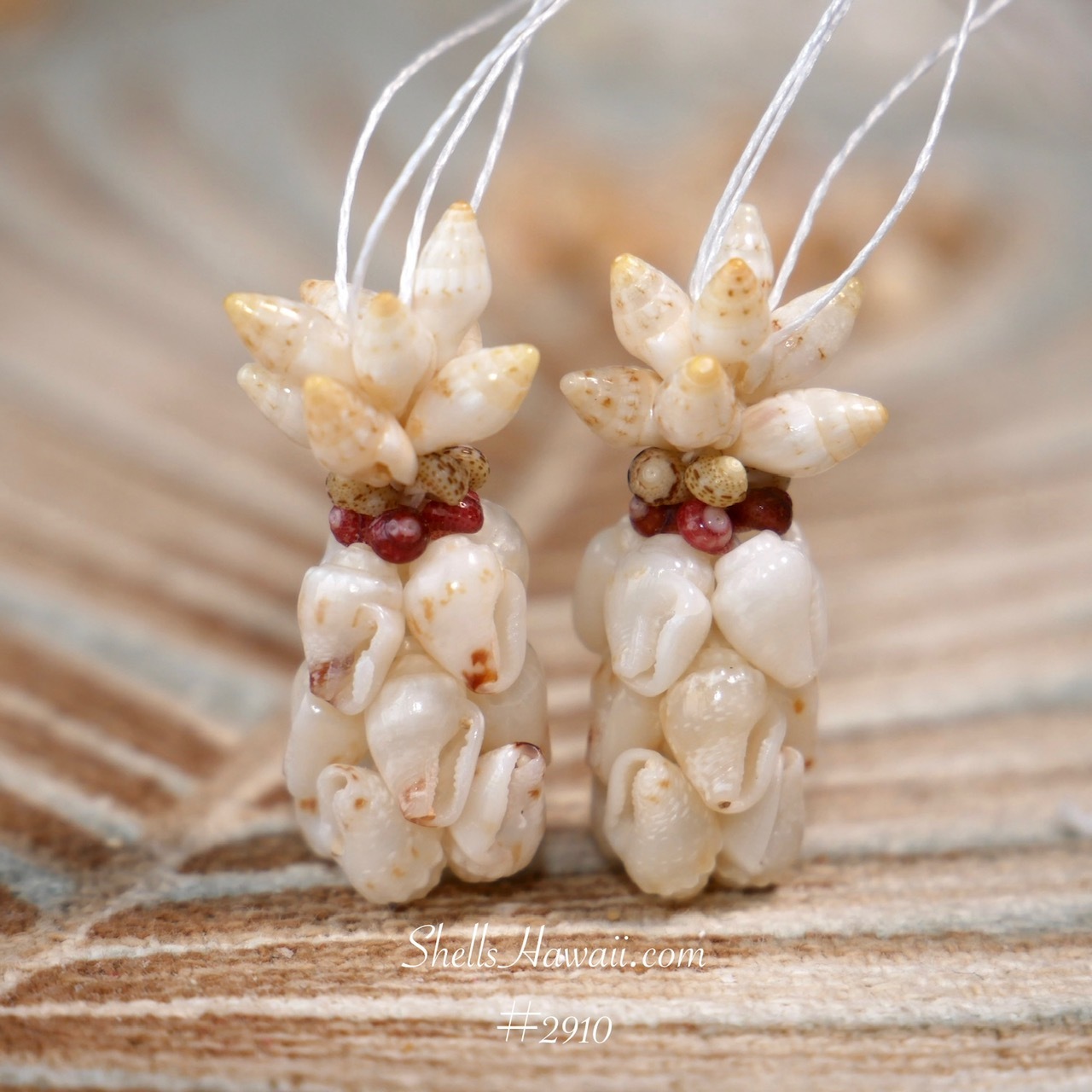 Soft off-white Momi shells with subtle blue undertone paired with light yellow Laiki and red burgundy with green Kahelelani accents in Hawaiian pineapple design earrings, handmade Niʻihau shell jewelry close-up