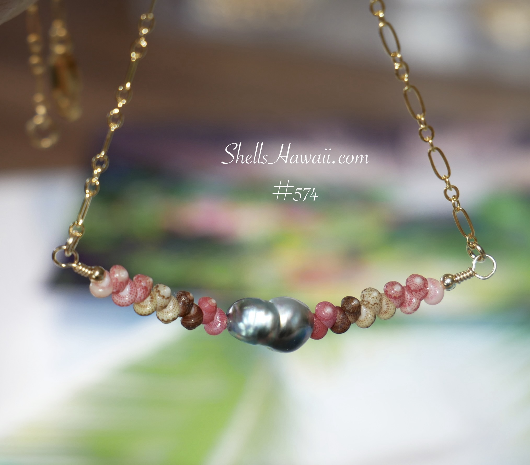 Minimalist Niʻihau shell necklace featuring genuine size 11 Kahelelani shells in hot pink, soft pink, brown, green, and cream tones arranged in a colorful floating design around a dark silver green Tahitian Keshi-style pearl centerpiece. Handcrafted Hawaiian shell necklace with organic baroque pearl and fancy Italian 14k gold filled chain in a lightweight tropical coastal style.