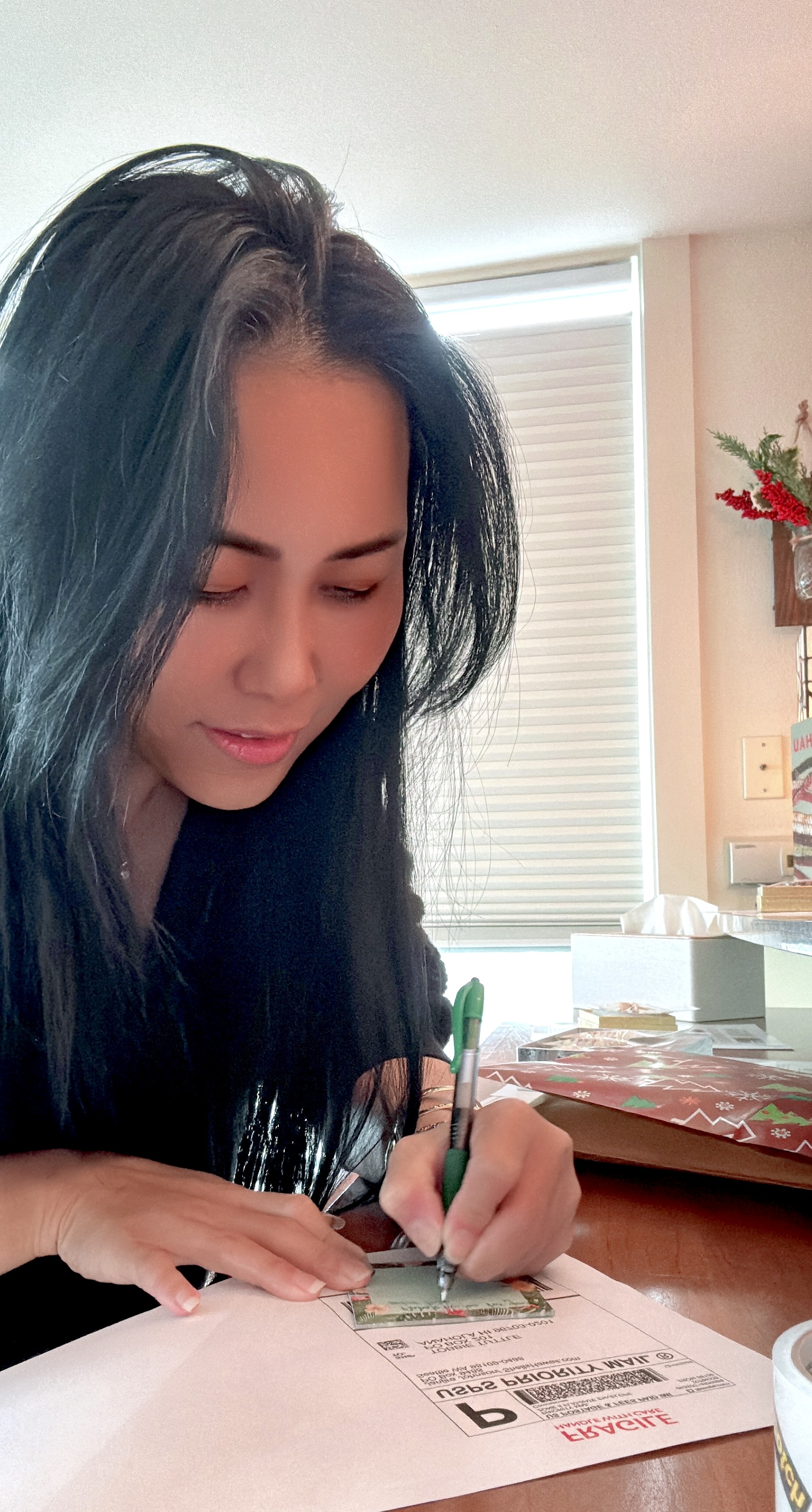 Handwriting a thank-you note while packing Niʻihau shell jewelry orders, a behind-the-scenes holiday moment at ShellsHawaii.