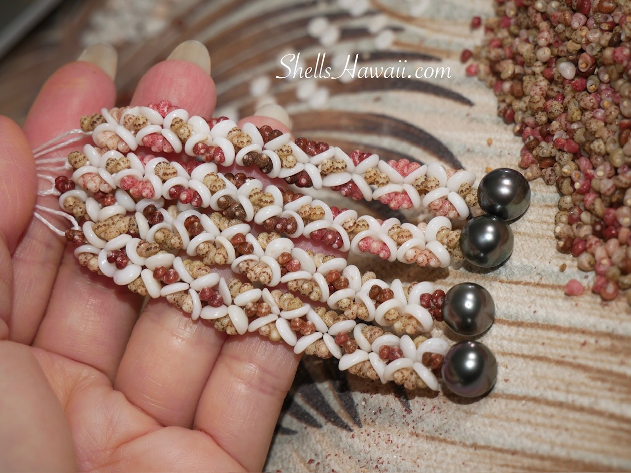 Close-up of finished flower-inspired Hawaiian shell jewelry handcrafted with genuine Kahelelani shells, Puka shells, and Tahitian pearls.