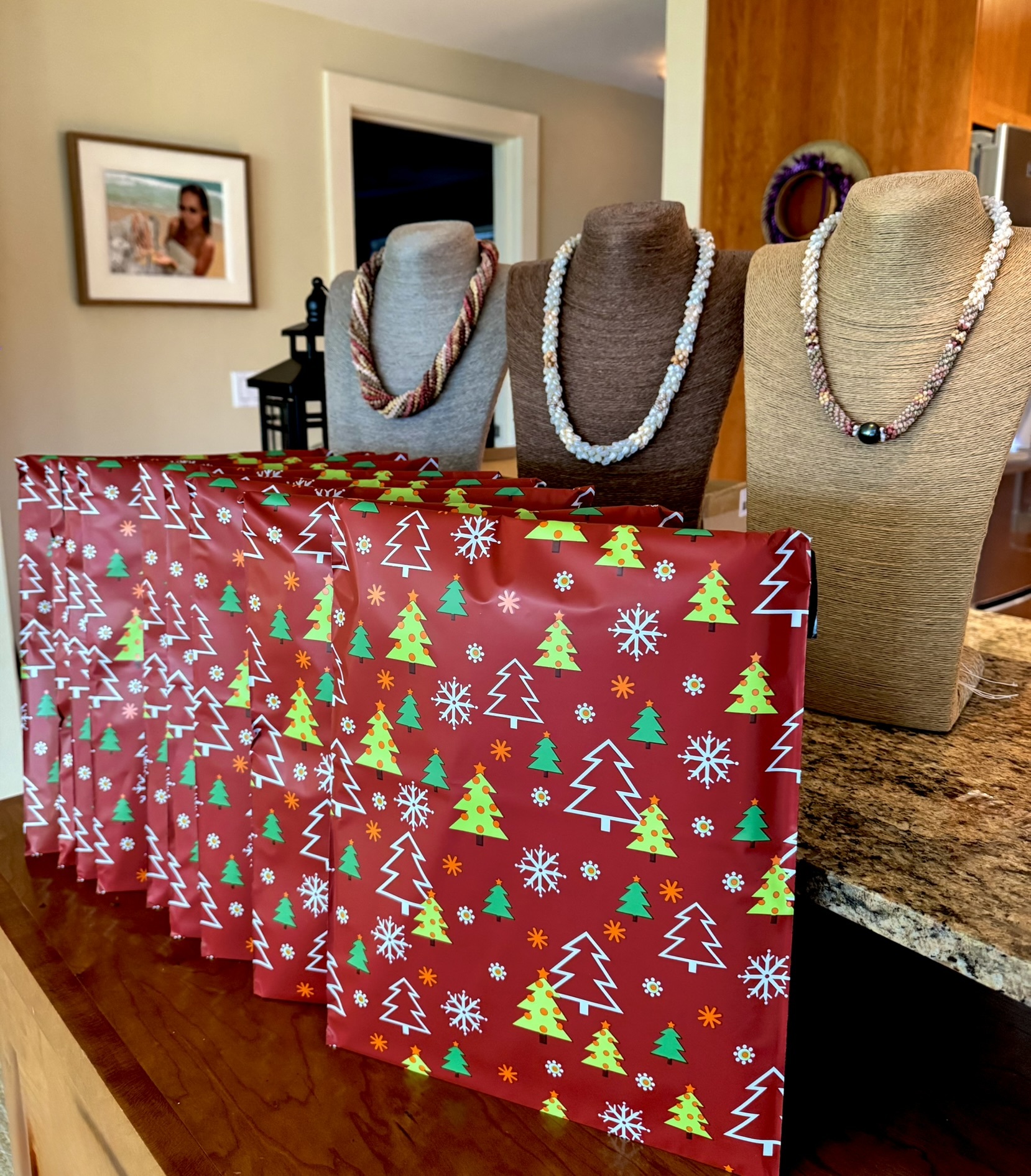 Handcrafted Niʻihau shell jewelry prepared as holiday gifts, with wrapped packages and finished necklaces ready to be given to loved ones
