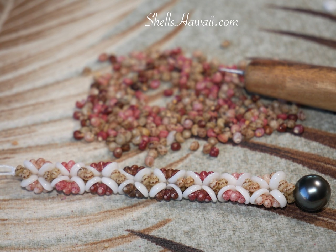 Handcrafted Hawaiian shell earrings featuring genuine Niʻihau Kahelelani shells in pink, brown, burgundy, green, and Keʻokeʻo, paired with bright white Puka shells and suspended from lustrous dark peacock Tahitian pearls with subtle silver overtones.