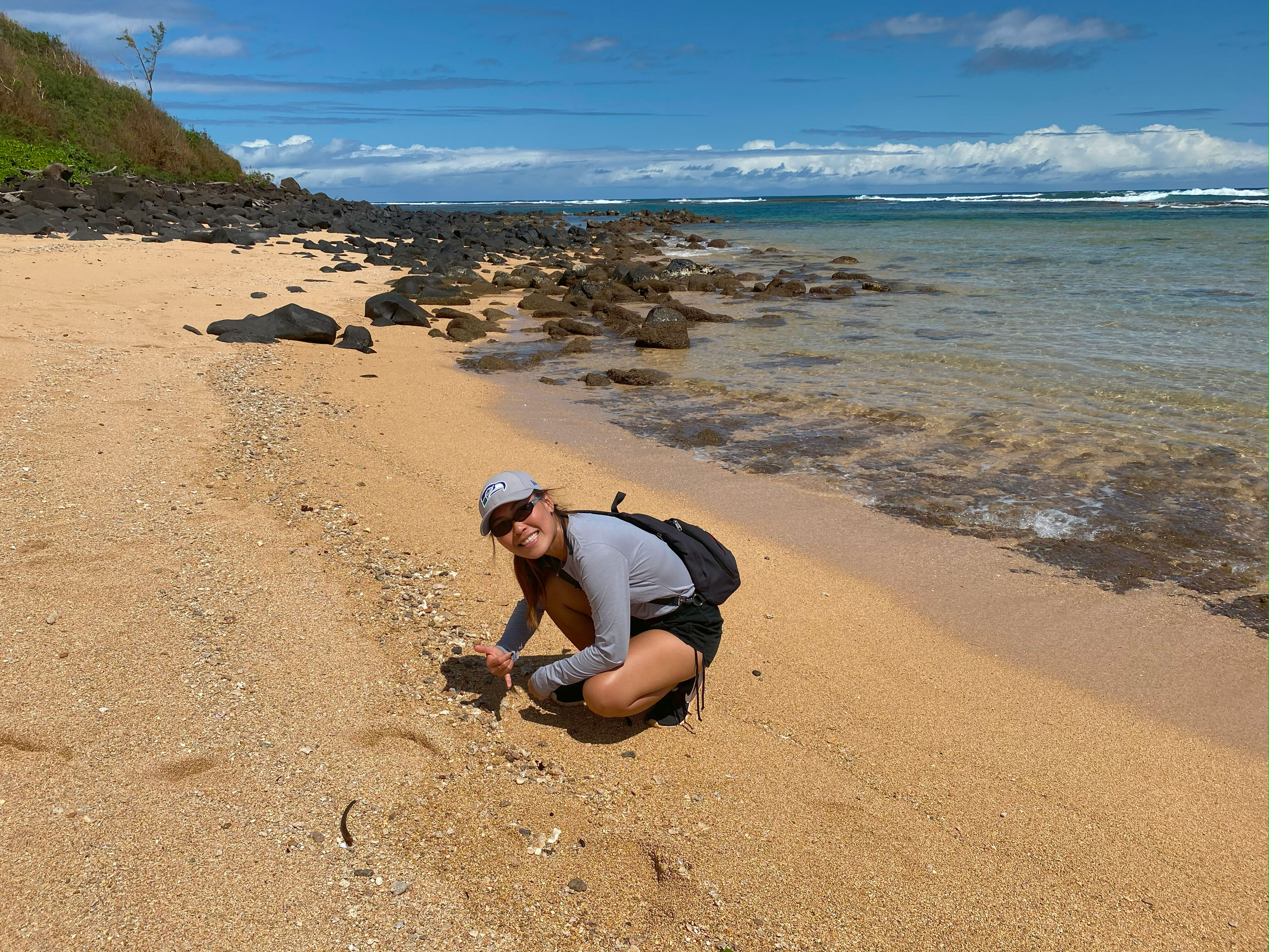 anjira, owner of ShellsHawaii, collecting Niʻihau shells by hand on a Hawaiian beach, showing the real work behind authentic Niʻihau shell jewelry