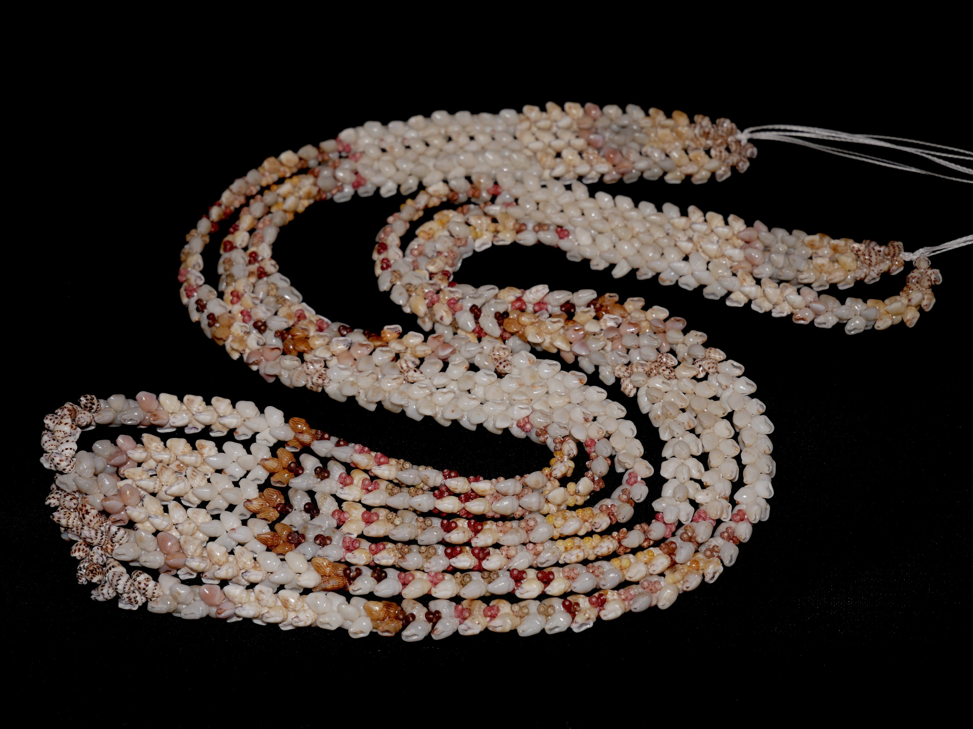 Niʻihau shell lei showing Heleconia style flow in a finished lei, demonstrating how the directional movement of Momi and Kahelelani shells creates smooth rhythm and balance even when mixed with other Hawaiian shell jewelry styles