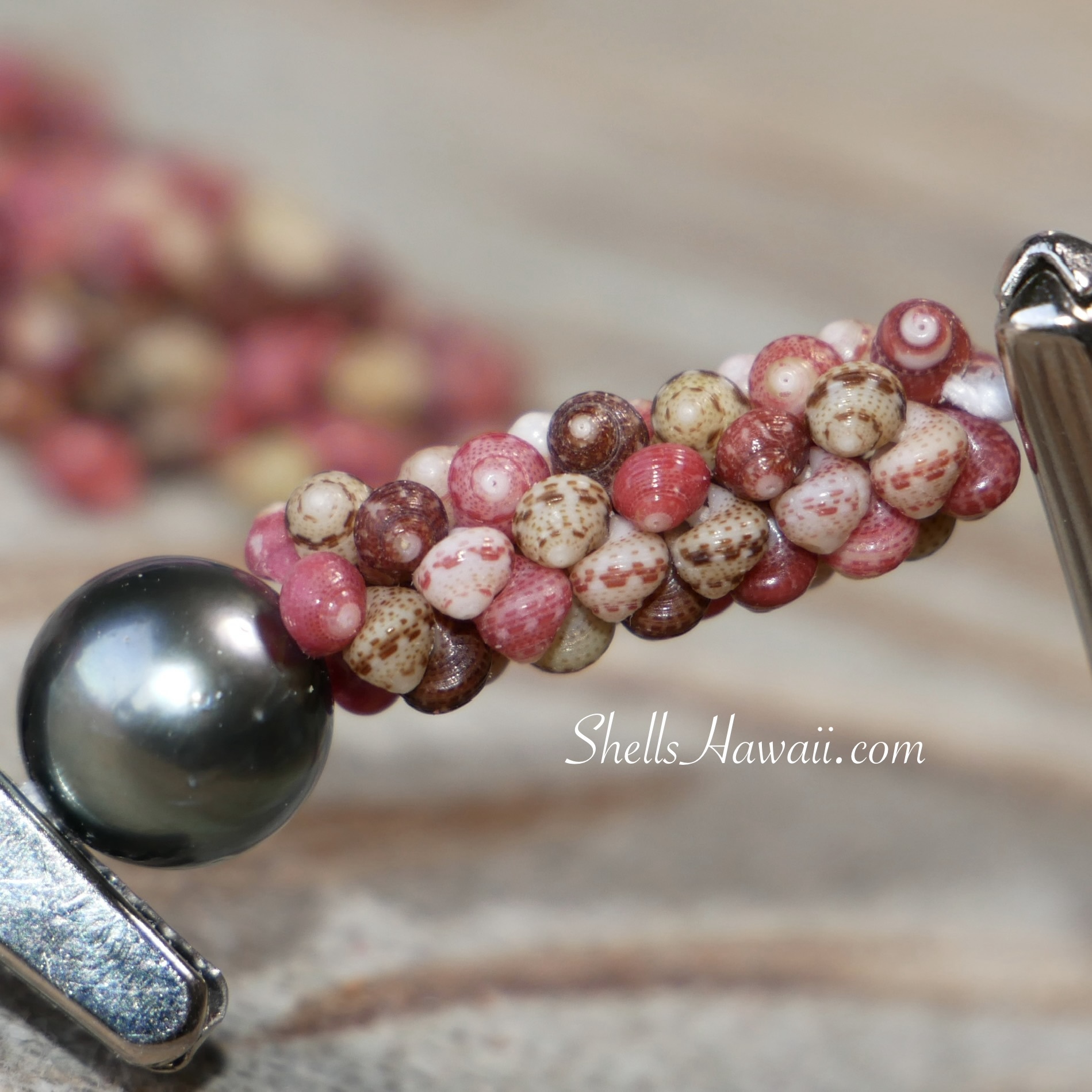 Close-up of tiny loose Niʻihau shells prepared for jewelry making, showing their small size, natural variation, and the careful handwork required before stringing.
