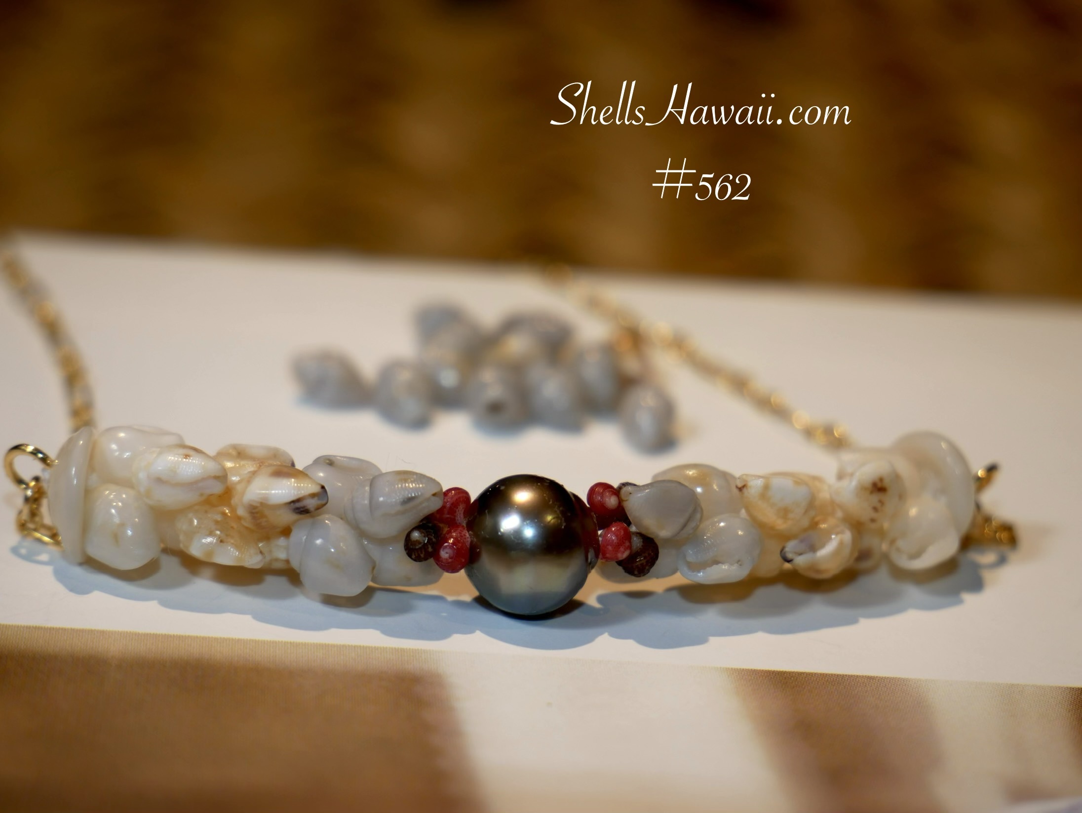 Finished Niʻihau shell pendant necklace featuring medium blue Momi shells alongside white Momi shells and a Tahitian pearl centerpiece, showing how rare ocean-developed blue tones appear once transformed into wearable jewelry.